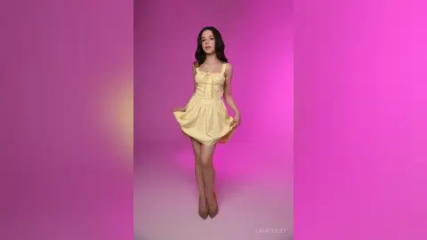 Young woman in a yellow sundress posing against a vibrant pink background with a playful mood.
