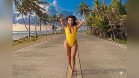 Woman in a yellow one-piece swimsuit standing on a tropical coastal road lined with palm trees at sunset.