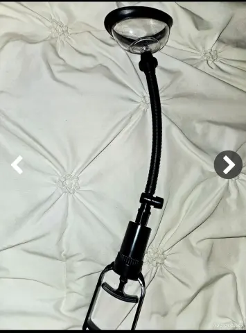 Black flexible neck clip light mounted on a white tufted fabric surface in a bright indoor setting.