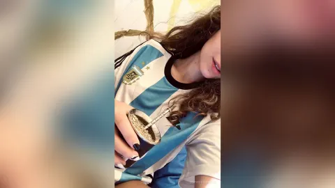 SophieeSunsett — SophieeSunsett wears an Argentina soccer jersey while holding a mate cup and straw.
