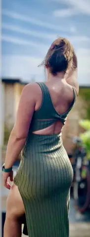 CurvyHannahXX poses outdoors in a tight, ribbed green dress that shows off her curves and backside.