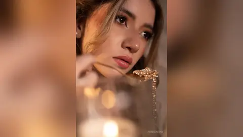 Close-up portrait of a young woman with soft lighting and a dreamy, warm mood.