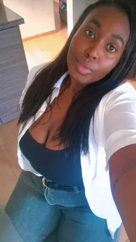 Young woman in a white shirt and black top posing indoors with a relaxed mood.