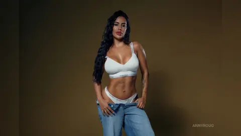 AnnyRoug poses in a white Calvin Klein bra and matching white undies with her blue jeans pulled down low over her hips.