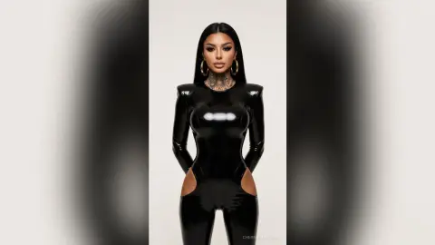 Glamorous woman in a sleek black latex bodysuit and gold hoop earrings posing against a minimalist background.