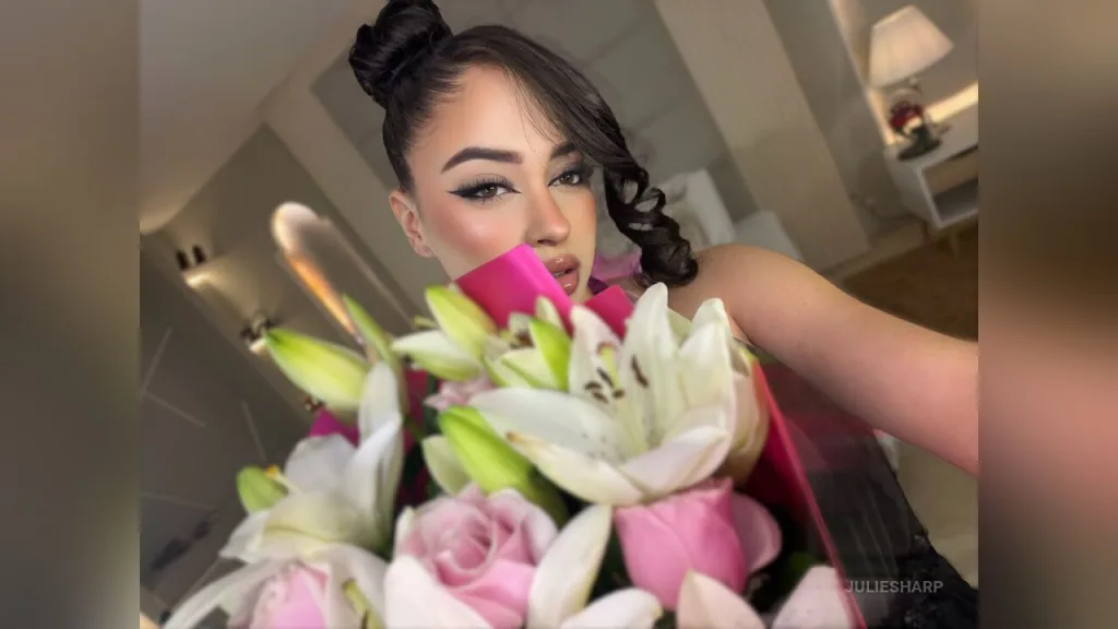 JulieSharp — JulieSharp holds a large bouquet of white and pink lilies while looking into the camera.