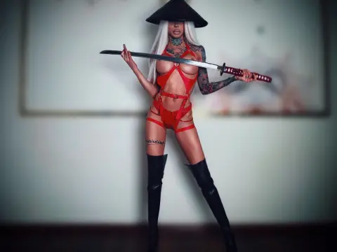 Tattooed woman in red lingerie and black boots holding a katana in a moody indoor setting.