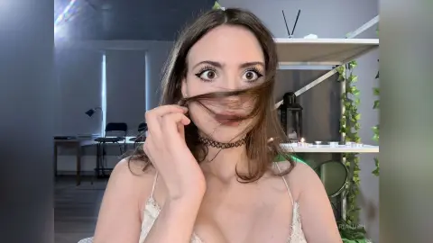 AriaLush peeks through her long brown hair while wearing a black choker and a white lace camisole in her room.