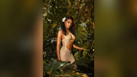 Beautiful woman in a beige crochet cutout dress posing in a lush tropical jungle setting with a dreamy mood.