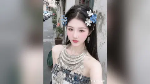 Young woman in ornate silver ethnic jewelry and floral hair accessories posing outdoors in a serene mood.
