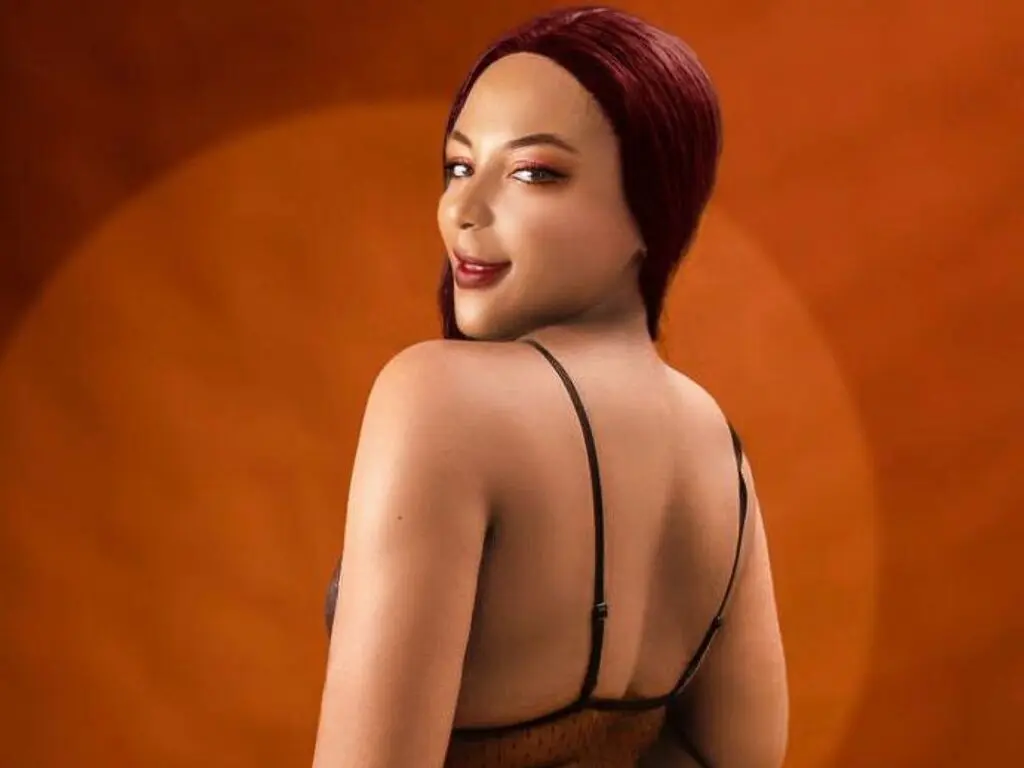 Smiling woman with red hair in a black spaghetti strap top against a warm orange background.