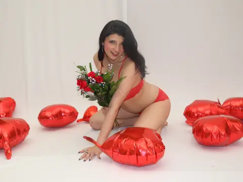 sweeteescape22 is a brunette in red lingerie kneeling on the floor with a bouquet of red roses and red heart balloons.