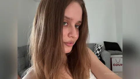 LeslieDorian looks into the camera with long brown hair in a casual indoor setting.