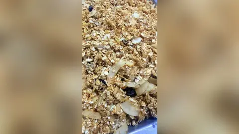 Healthy homemade granola mix with oats, dried fruit, and nuts in a close-up bowl view.