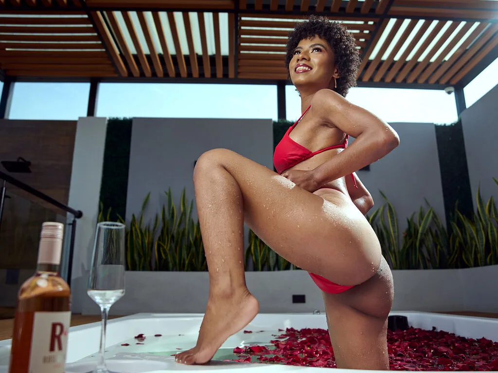 KylieDecks — KylieDecks poses in a red bikini beside a white bathtub filled with red rose petals.