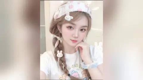 Young woman with braided hair and bunny accessories wearing a white graphic tee in a bright, soft aesthetic mood.