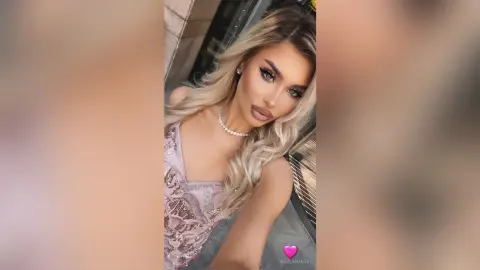 Blonde woman in a sparkly pink sequin dress posing with glamorous makeup in a modern setting.