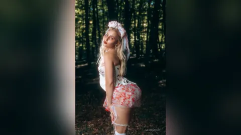 MishaNight — MishaNight poses in a white and red floral lace outfit and headband while standing in a sunlit forest.
