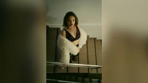 Elegant woman in a lace bra and white faux fur stole posing on a staircase with moody lighting.