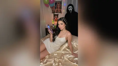 Woman in a white satin slip dress sitting on a bed next to a Ghostface character in a spooky bedroom setting.