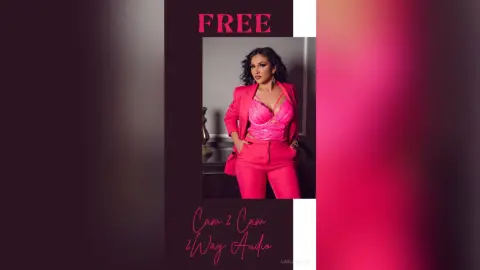 Confident woman in a hot pink blazer and matching corset outfit posing in a stylish indoor setting.