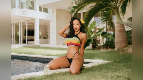 Beautiful woman in a colorful crochet bikini relaxing by a luxury villa pool on a sunny tropical day.