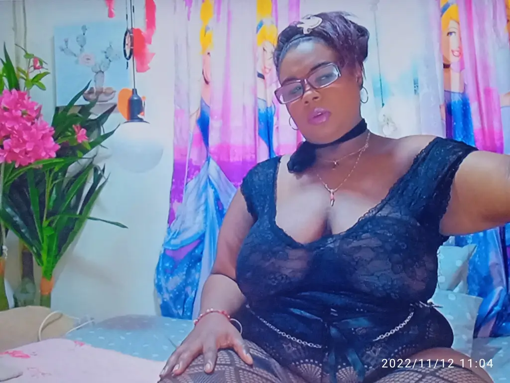 valentineanai wearing a black top and baseball cap posing in her room.