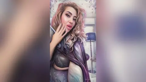 Glamorous woman with wavy blonde hair wearing a stylish purple outfit in a soft, dreamy indoor setting.