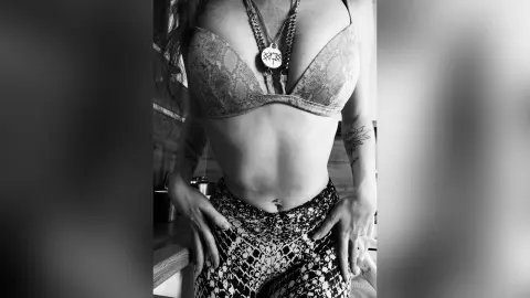 RubyAttwood poses in a lace bra and patterned bottoms, showing her midriff and tattoos.