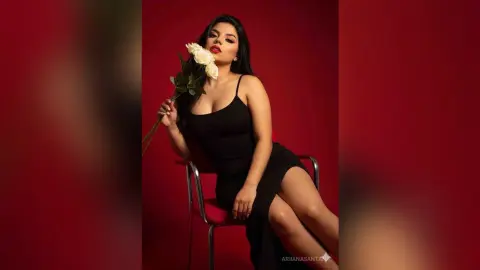 Elegant woman in a black cocktail dress holding white roses against a moody red background.