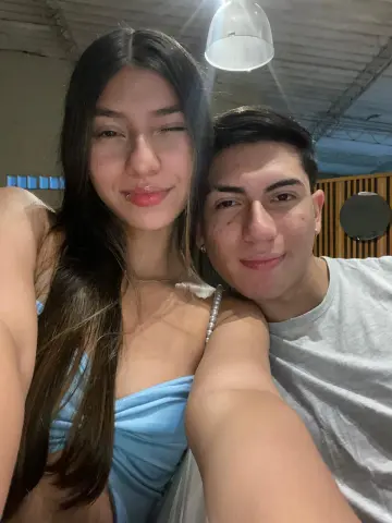 Smiling young couple in casual summer outfits sharing a happy selfie moment indoors.