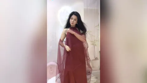 KireliaYan — KireliaYan poses in a flowing maroon sheer dress with her long black hair down.