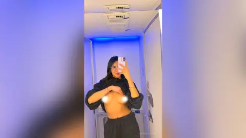 VeronicaValdez holds a phone for a mirror selfie, lifting her black shirt to expose her bare breasts.