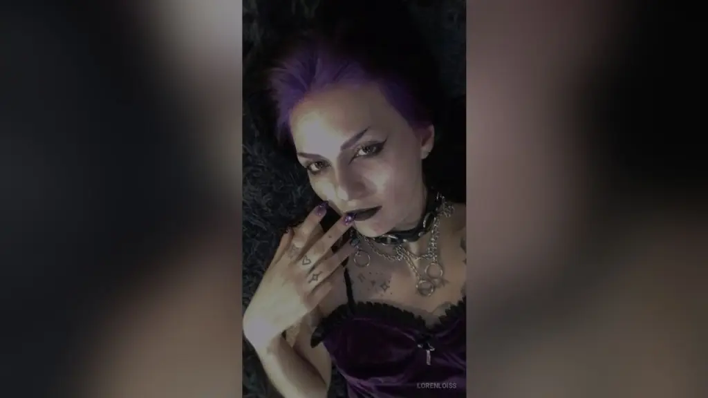 LorenLoiss — Moody portrait of a woman with purple hair wearing a black lace corset and silver necklaces.