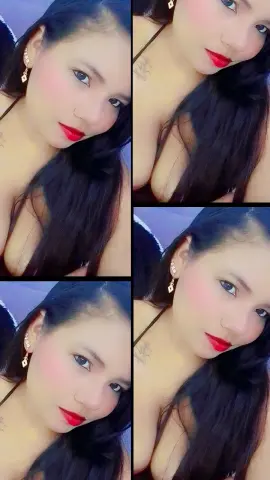 Young woman with long dark hair and red lipstick posing in a soft indoor setting.