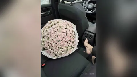 AlienaMoore — AlienaMoore sits in the passenger seat of a car with a massive bouquet of pink roses on her lap.