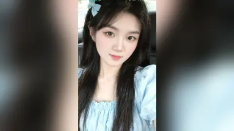 Young woman with long dark hair wearing a light blue puff-sleeve blouse in a soft, dreamy aesthetic.