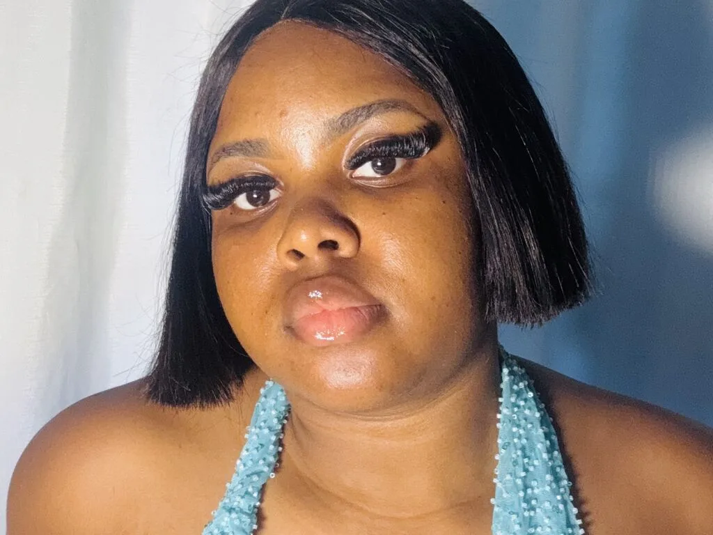 RoseSylver poses in a light blue sequined halter top against a white fabric background.