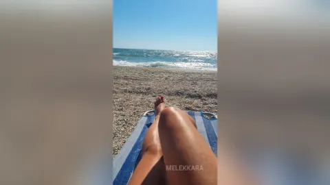 MelekKara — MelekKara relaxes on a blue beach chair with her legs stretched out toward the ocean waves.