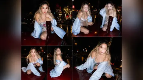 Young woman in a light blue oversized shirt and lace lingerie sitting outdoors at night with a moody aesthetic.