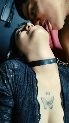 Intimate couple sharing a romantic moment with a woman in a black lace top and leather choker.