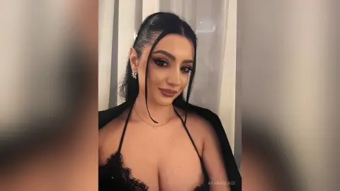 Glamorous woman in a black lace outfit and silver earrings posing with elegant makeup in a soft-lit setting.