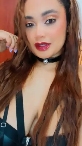 NiaMorelli wearing a black choker and black lingerie, posing with her hair down and red lipstick.