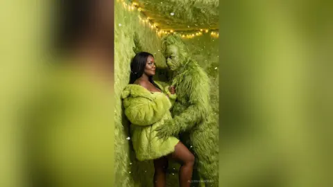 Woman in a fuzzy lime green coat embracing a person in a green furry monster costume in a whimsical green room.