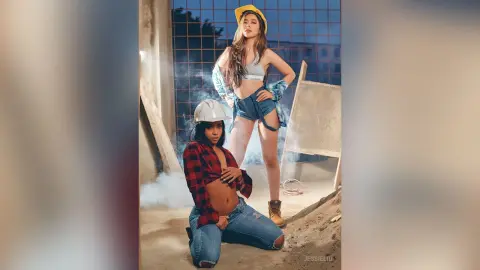 JessieLiu wears a white hard hat and a red plaid shirt, posing in denim shorts against a construction site background.