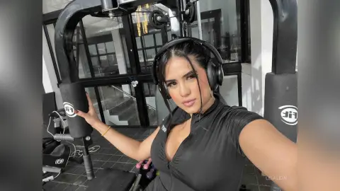 LeiaLein — Smiling woman in black athletic wear wearing headphones in a modern gym setting.