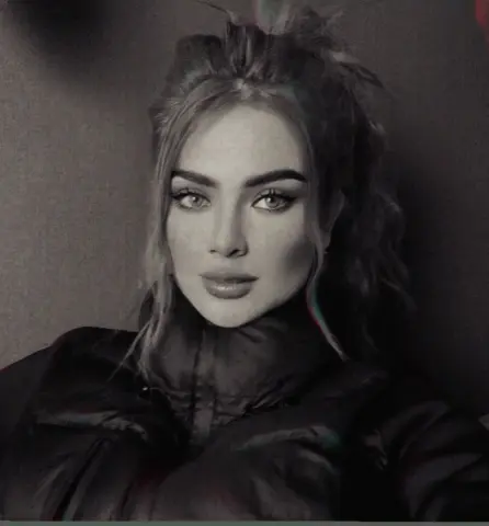 Portrait of a blonde woman in a black puffer jacket with a moody, cinematic aesthetic.