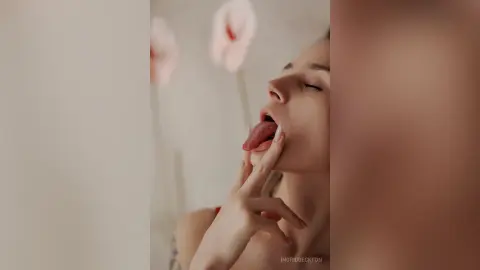 IngridBeckton licks her lips with her finger touching her mouth, showing her tongue and closed eyes.