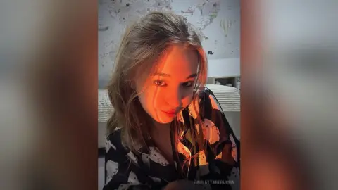 PaulettaRerucha looks toward the camera while wearing a black and white patterned shirt or robe.