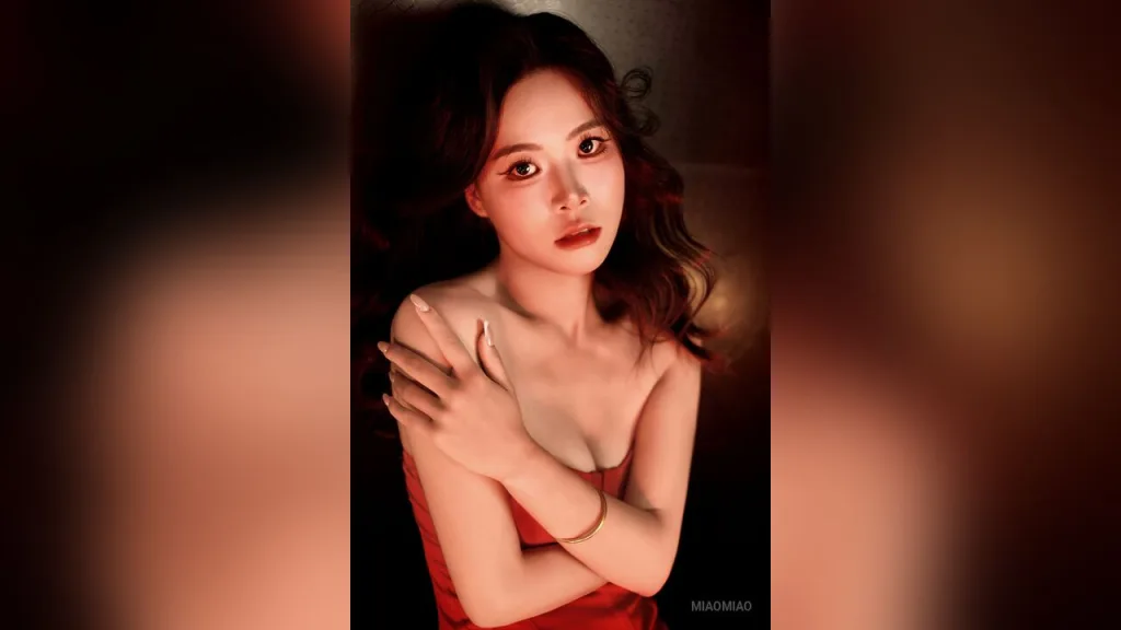 miaomiao lies naked on a red velvet sheet, looking at the camera with her dark hair spread out.